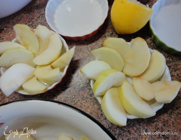 Керамические порционные формочки смазать немного оливковым маслом и выложить дольки яблок, как показано на фото.