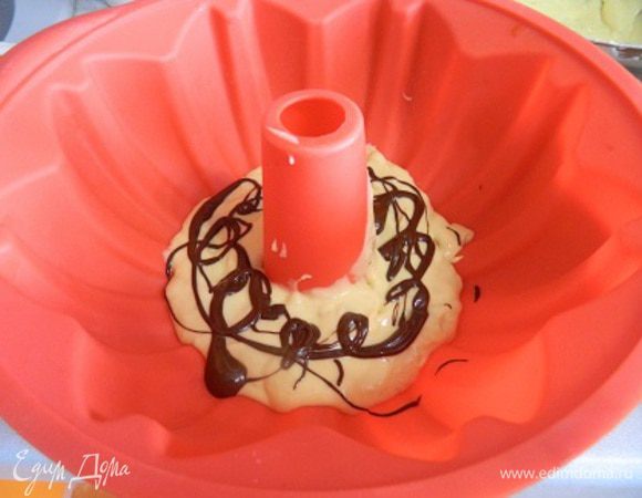 Форму смазать маслом. У меня силиконовая, я не смазываю. Выложить часть белого теста (слои будут чередоваться), затем немного растопленного шоколада.
