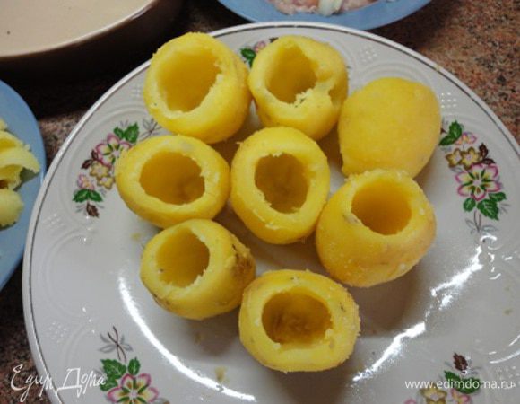 1.	Картофелины должны быть одинаковые по размеру. Картофель помыть и отварить в кожуре в кипящей соленой воде 15 минут ( до полуготовности).
2.	Воду слить, картофель облить холодной водой и очистить от кожуры. У каждой картофелины с противоположных сторон сделать срезы (для устойчивости) и вынуть из середины часть мякоти.
