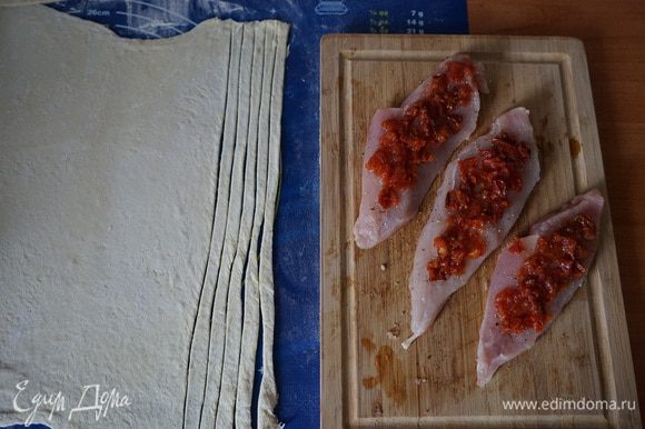 Вяленые помидорки (кстати, от Галиюши http://www.edimdoma.ru/retsepty/60099-vyalenye-pomidory) мелко режем и выкладываем на филе. Слоеное тесто тонко раскатываем и нарезаем длинные полоски.