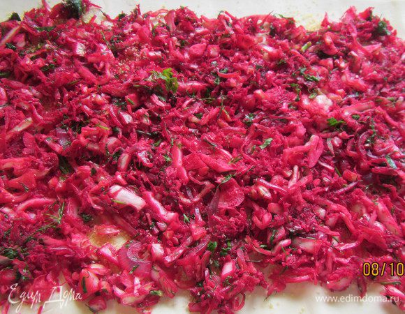 Добавляем капусту и свеклу, посыпаем сахаром и перцем, перемешиваем и готовим минут 7. Смешиваем капуствую начинку с зеленью и распределяем ее по тесту.

