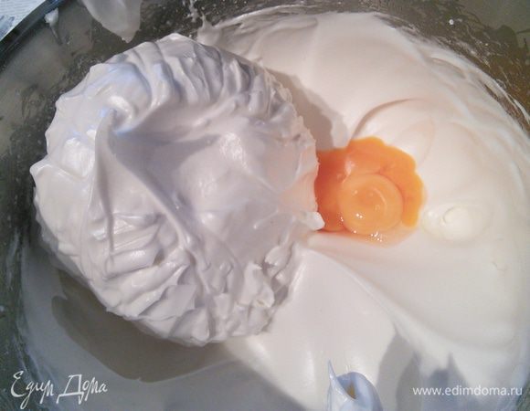 В белки вводим желтки, аккуратно размешиваем. 