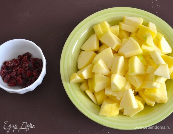Тем временем для начинки очистить яблоки и нарезать кусочками. Вишню можно разрезать пополам, если ягоды достаточно крупные.