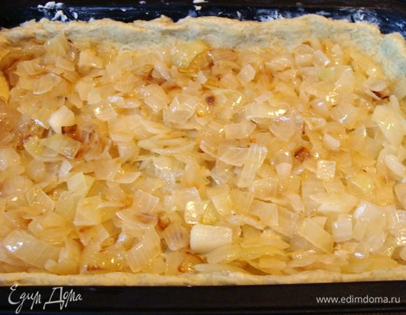 Две средние луковицы почистить, порезать, обжарить до золотистого цвета, можно до полуготовности. Выложить на замороженное тесто.