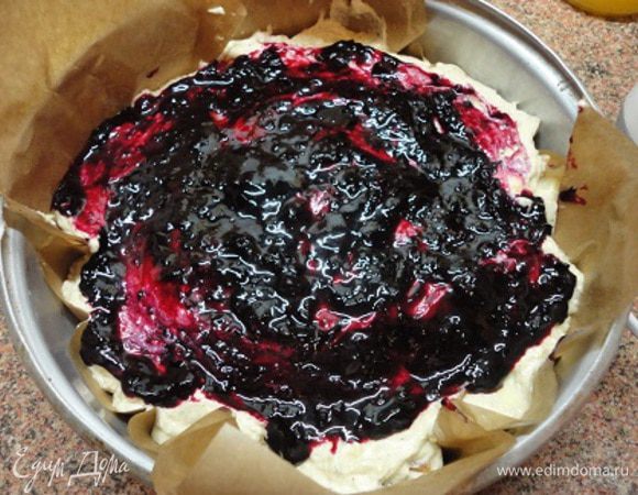 Форму (у меня диаметр 23 см) смазать маслом и застелить бумагой, еще раз смазав маслом. Выложите тесто. Сверху начните добавлять варенье, рисуя причудливые рисунки. Так советует автор. Но у меня варенье густое, рисунки не получились и я просто смазала верх кекса вареньем.