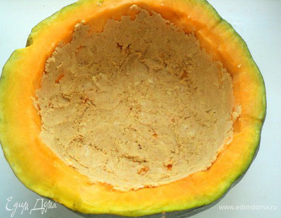 Выложить маслянистой крошкой стенки тыквы, уплотнив ложкой.