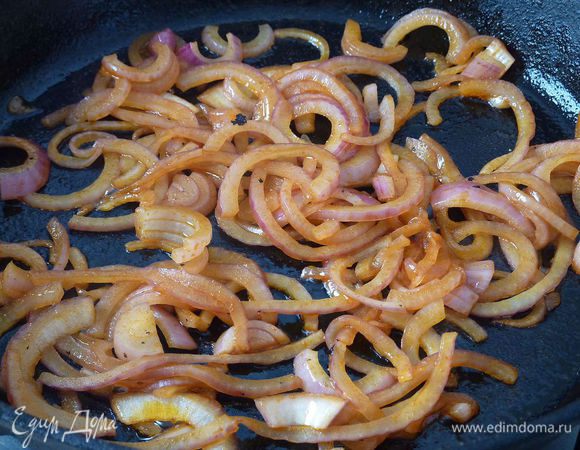 Разогреть духовку на максимальный градус.
Лук тонко порезать . 
В чугунной сковороде разогреть масло . Обжарить лук минут 7.