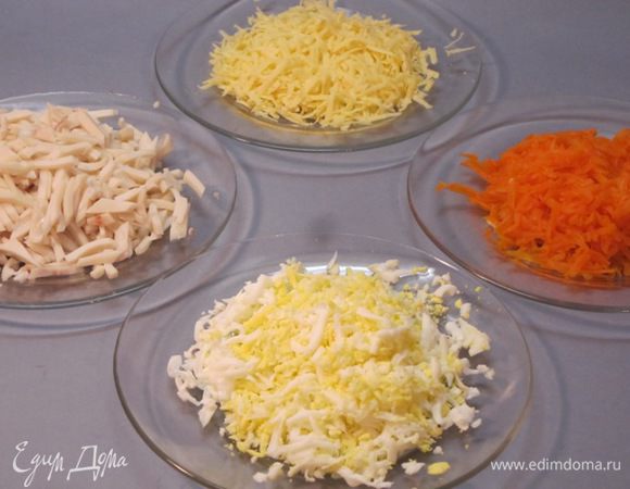 Яйца отварить, очистить, остудить, натереть на крупной терке. Кальмары очистить, отварить 3 минуты в кипящей подсоленной воде, остудить, мелко нарезать. Морковь отварить, очистить, остудить, натереть на крупной терке. Сыр лучше натереть на мелкой или средней терке. Я натерла на крупной, так сложилось.
