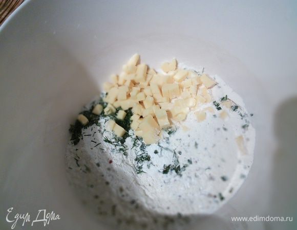 Муку смешать с разрыхлителем, мелко нарубленным розмарином и любыми другими травками, половиной натертого на терке сыра, солью и перцем. 