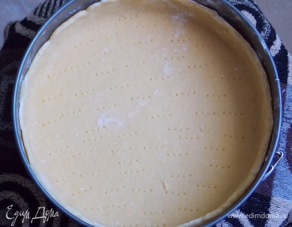 Тесто раскатать на посыпанном мукой столе, выложить в форму, формируя бортики, наколоть вилкой и охладить в течение часа.