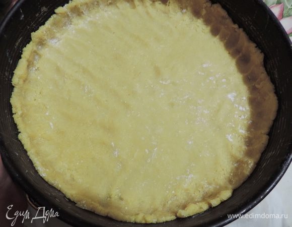 Делим тесто примерно на 34/4 и 1/4. Большую часть распределяем по форме диаметром 26см, дно которой желательно предварительно выстелить бумагой для выпечки. Бортики можно не смазывать.