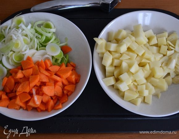 Подготовить овощи. Вымыть, очистить... Лук порей нарезать кольцами, морковь и картофель - небольшими кубиками, чеснок - "лепестками".