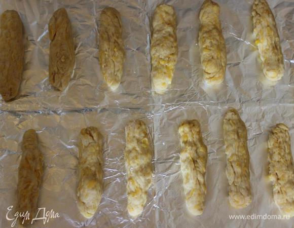 Насыпаем примерно 1 ст.л. муки (не более) на рабочую поверхность. 
И, «окуная» руки в муку, чтобы тесто не липло, отщипываем кусочки примерно с крупный грецкий орех и формируем из них колбаски.
У меня получается 10-14 штук в зависимости от размера.
