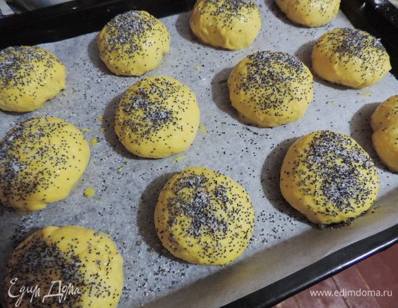 Подошедшее тесто необходимо слегка обмять и разделить на 16 равных частей. 
Каждый кусочек теста расплющиваем в лепешку, по желанию кладем начинку (у меня сливовое повидло, если у вас повидло жидковато, можете добавить к нему немного крахмала, чтоб оно не убежало при выпекании), залепливаем края и формируем круглую булочку. Выкладываем булочки на противень с бумагой, смазываем слегка взбитым яйцом, посыпаем смесью мака и сахара. Оставляем минут на 15.