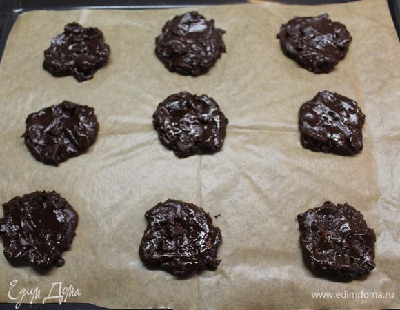 На застеленный пергаментной бумагой противень столовой ложкой выкладываем тесто, придавая ему округлую форму.