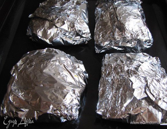 Завернуть фольгу, свернув и обжав поднятые края сверху. Положить конверты на противень и поставить в разогретую до 180 град. духовку. Запекать 1 час.