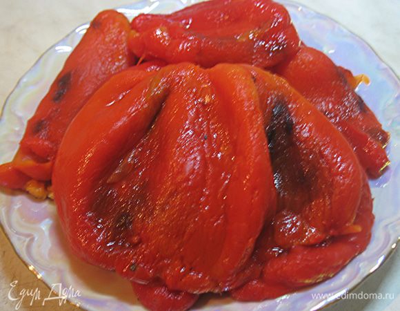 Перец вымыть, высушить и запечь в духовке.  Периодически переворачиваем перец, чтобы он равномерно пропекся. Когда перец будет готов достаем из духовки.  Кладем в миску и закрываем крышкой (можно поместить в пакет), чтобы перец пропарился. Очищаем перец от шкурки и семян. 