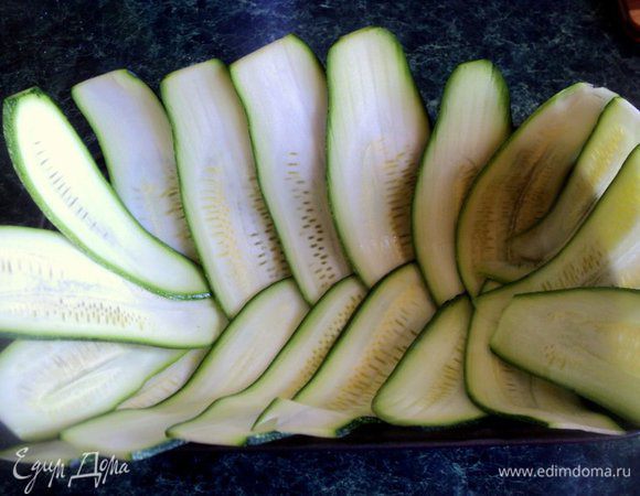 Форму размером 10х20см смазать растительным маслом. Стенки и дно формы выложить внахлест  пластинками кабачка.