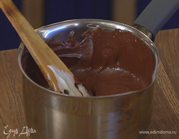 Приготовить глазурь: оставшиеся 150 г шоколада поломать кусочками, поместить в кастрюлю, влить 75 мл сливок и растопить все на медленном огне. Затем снять с огня, добавить 75 г сметаны и вымешать.