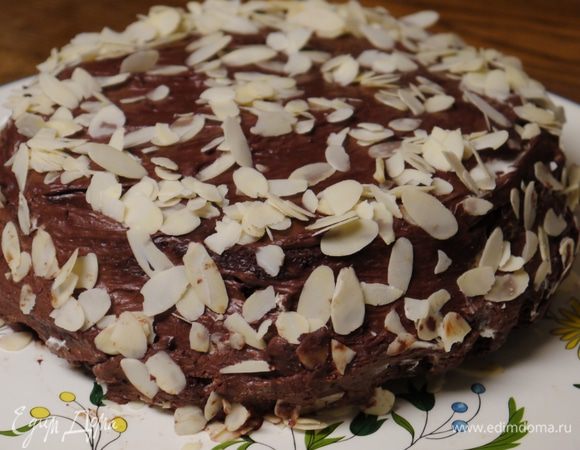 Покрыть верх и бока торта глазурью и посыпать миндальными хлопьями.
Подавать торт с оставшимся кремом.
