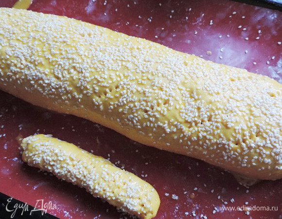 С помощью бумаги иликоврика сворачиваем наше тесто рулетом. Защипываем края. Рулет накалываем вилкой, чтоб он не лопнул во время выпекания. Смазываем рулет слегка взбитым яйцом. Щедро посыпаем наш рулет кунжутом и отправляем в разогретую до 180-190 градусов духовку. Выпекаем до красивого золотистого цвета 30-35 минут