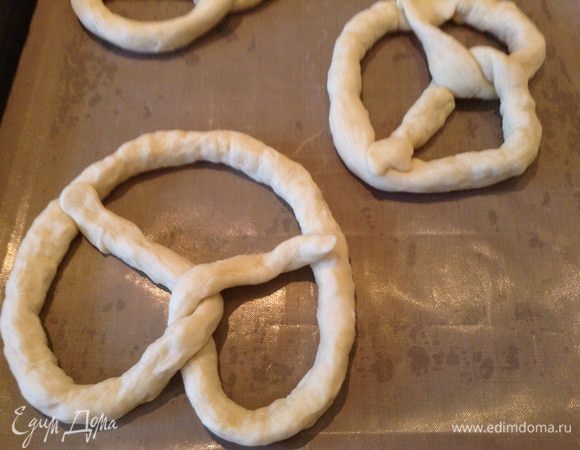 Из каждой части теста скатать колбаску( 50см) и сформировать крендель.передожить на противень и дать "отдышаться"( 30мин).