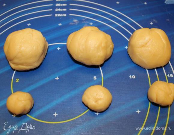 Тесто разделить на 8 частей. От каждой отщипнуть по небольшому кусочку. Получается примерно 8 "мячей для гольфа" и 8 "грецких орехов"
