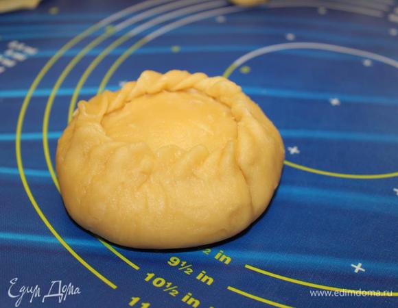 Маленький шарик теста тоже немного раскатать, уложить его поверх начинки. Края нижнего теста поднять вверх и залепить (соединить с верхним тестом). По окружности сделать красивые защипы.