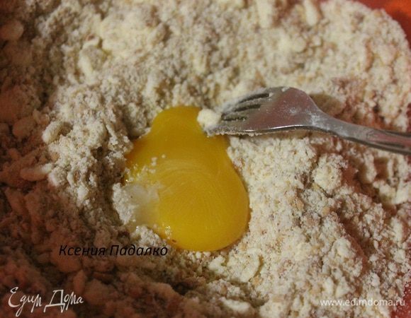 К полученной смеси добавляем желток и перемешиваем руками. Затем добавляет ложку ледяной воды и опять перемешиваем, если тесто не желает собираться в ком, то добавляем еще одну ложку воды.