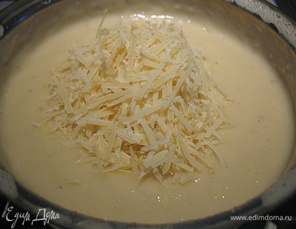 Взбить яйца, натереть сыр.  Добавить взбитые яйца и тертый сыр с немного остывший соус и перемешать. 