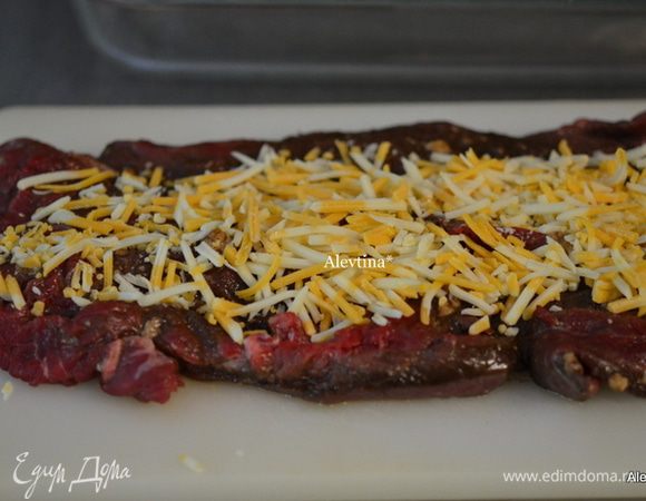 Достать говядину из маринада, посолить и поперчить, выложить слой сыра.
