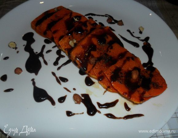 Разогреваем духовку до 180 С и отправляем туда нашу тыкву на 20-25 минут. За это время сахар расплавится. смешается с лимонным соком и превратится в жидкую карамель которая пропитает кусочки тыквы. На водяной бане растапливаем пол плитки шоколада. Выкладываем тыкву на тарелку, поливаем шоколадом и посыпаем орешками. Наслаждаемся полезным и вкусным десертом!!!