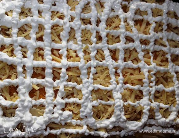 Посыпать сыром и нанести на него сеточку из сметаны (или просто смазать). 
Если любите, используйте майонез.