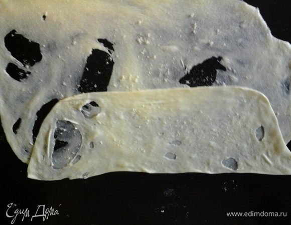 Тонко растягивать каждый шарик на смазанной маслом поверхности.
Сверху растянутое тесто посыпать мукой и смазать сливочным маслом.
посыпть семолиной.