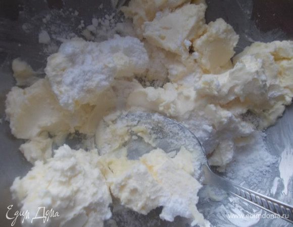 Масло должно быть мягким,его нужно взбить с сахарной пудрой.добавить воды и еще немного взбить,пока вода не соединится с маслом и разделить тесто на две части.