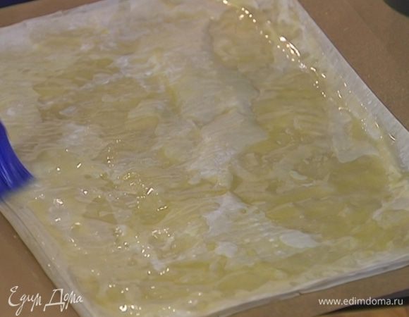 Лист фило выложить на противень, смазать половину сливочным маслом, сложить пополам и смазать сверху. Так же поступить со вторым листом, положив его на первый (немного растопленного масла оставить).