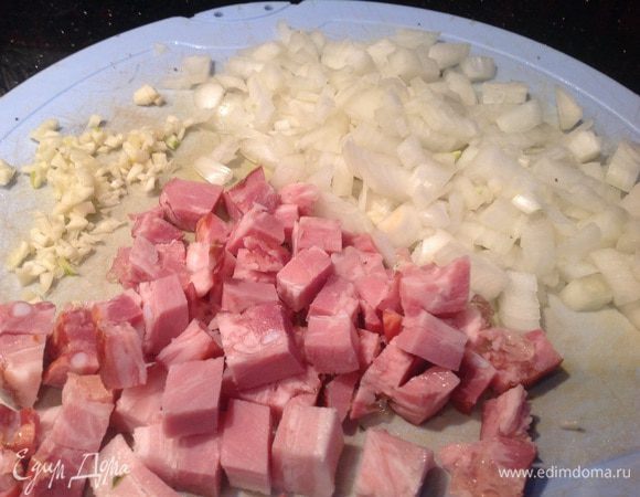 Почистите лук и чеснок. Бекон нарежьте кубиками, лук и чеснок мелко порубите.