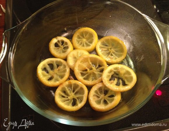 Лимон порезать на дольки. Разогреть оливковое масло в сковороде, добавить дольки лимона, кумин и мёд. Медленно потушить, время от времени переворачивая, пока жидкость не карамелизуется. Переложить лимоны на дно формы для запекания.