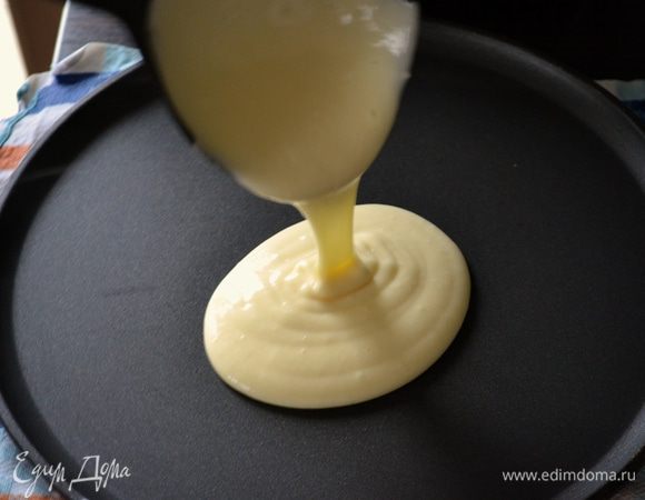 Сразу же выложить в центр сковороды пол половника теста и вернуть сковороду на огонь.