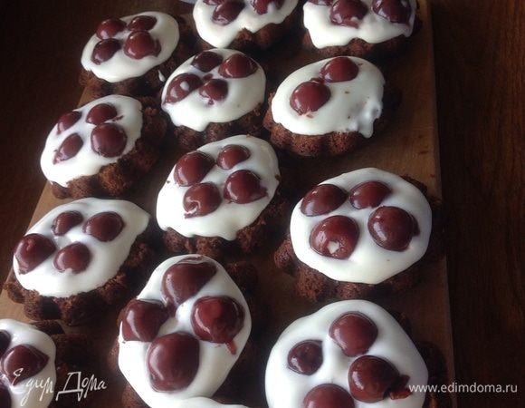 Готовые кексы остужаем в формочках, потом аккуратно вынимаем, разрезаем пополам, на ту часть которая больше в диаметре намазываем хорошим слоем крем и выкладываем вишню без косточек.