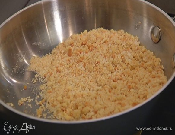 Сухари измельчить в блендере в мелкую крошку, высыпать в небольшую сковороду, сбрызнуть оставшимся оливковым маслом и подсушить до золотистого цвета.