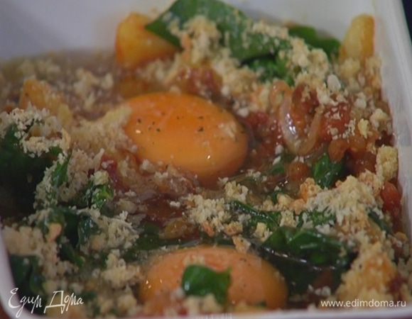 В небольшую керамическую форму выложить обжаренные овощи со шпинатом, сделать два небольших углубления и разбить в них яйца, посолить, поперчить и посыпать сухарями.