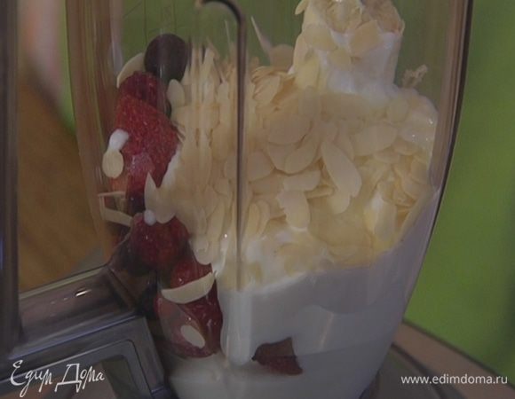 В чашу блендера поместить банан, ягоды, миндальные лепестки (немного оставить), влить йогурт, кленовый сироп и взбить все в однородную массу.