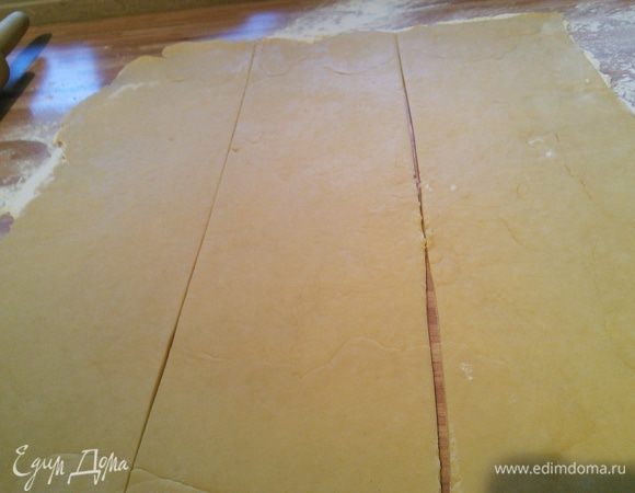 Тесто раскатать на присыпаной мукой поверхности в прямоугольник 30×40 см. Разрезать на три одинаковые по ширине полоски. 