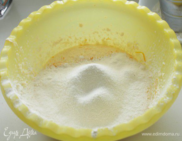 Добавляем половину просеянной с солью, содой и разрыхлителем муки, перемешиваем. 