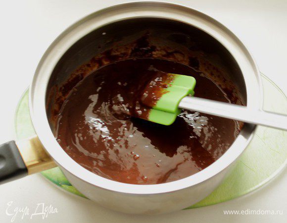 Готовим ганаш. Для этого мелко рубим шоколад и заливаем его доведенными до кипения сливками. Размешиваем до однородности.