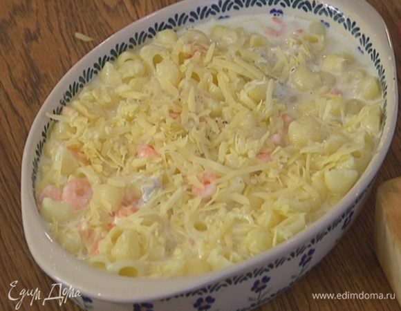 Макароны в форме залить горячим молоком и посыпать оставшимся сыром.