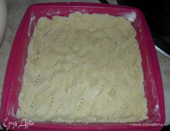 Тесто достать из холодильника и распределить его по дну смазанной формы (20х20) , сделав небольшие бортики. Наколоть вилкой и выпечь в разогретой до 180 С духовке 10 минут. 