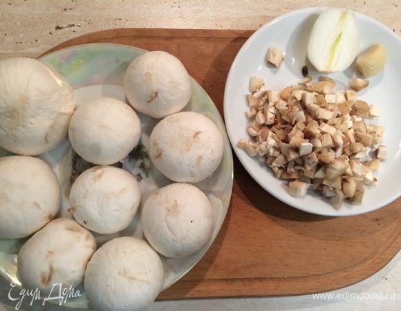 Шампиньоны вымыть, отделить ножки от шляпок. Шляпки грибов почистить, аккуратно вырезать мякоть, чтобы не повредить шляпки. Ножки грибов мелко порезать. 