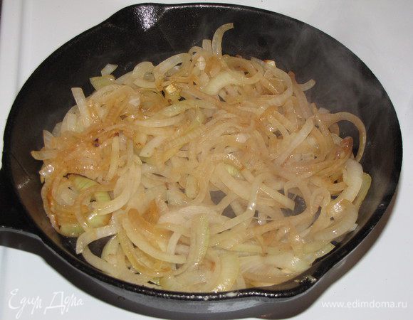 Лук нашинковать тонкими полукольцами и обжарить до мягкости.